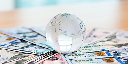 Glass globe and US dollar bills.