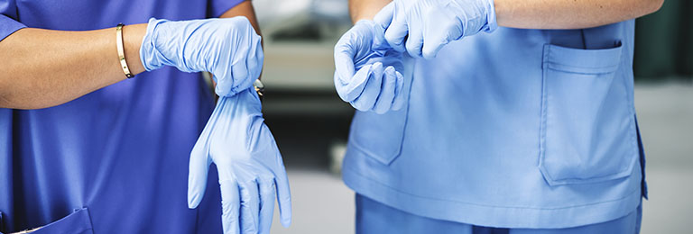 Surgeons wearing gloves preparing for surgery
